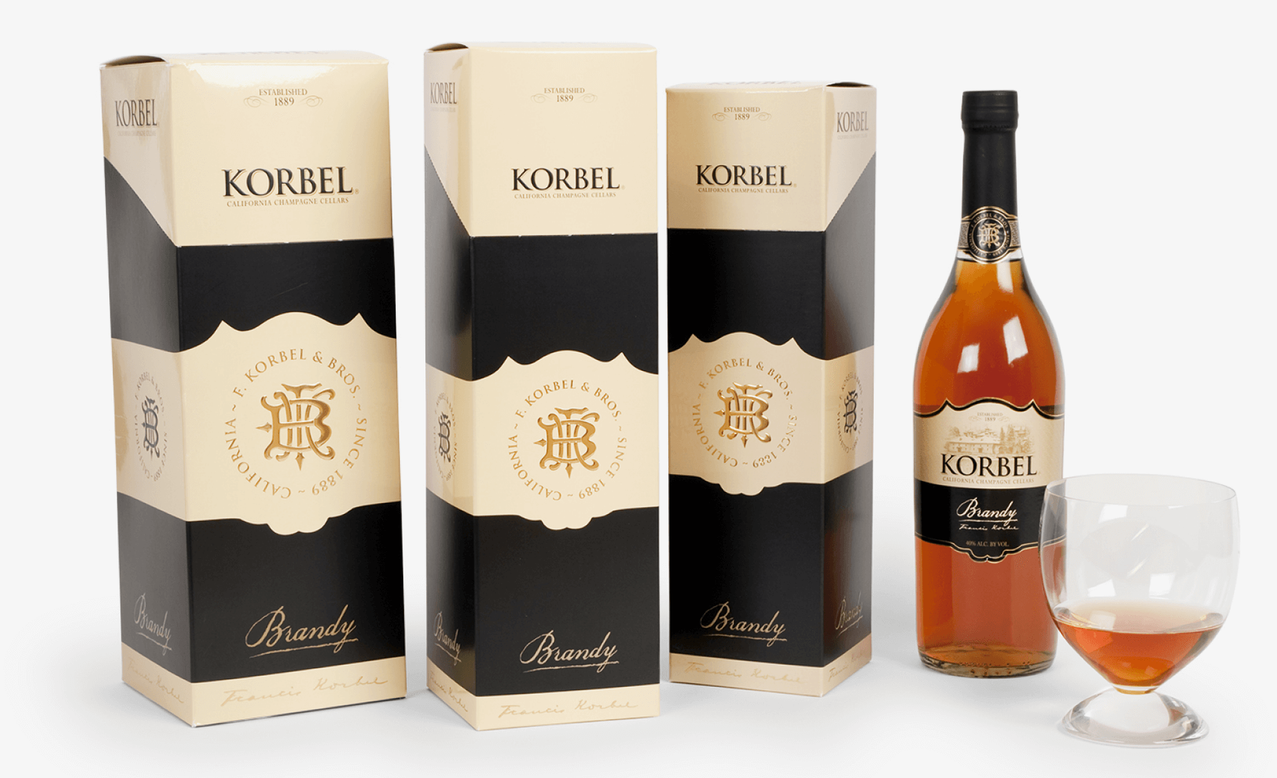 A bottle of korbel wine and a glass next to it.