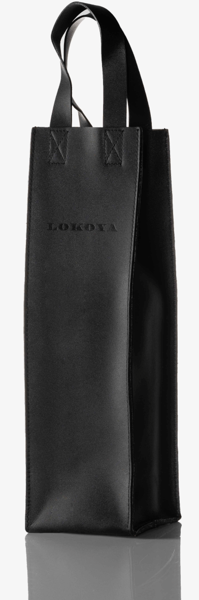 A black leather tote bag placed on a white surface, ready for packaging.