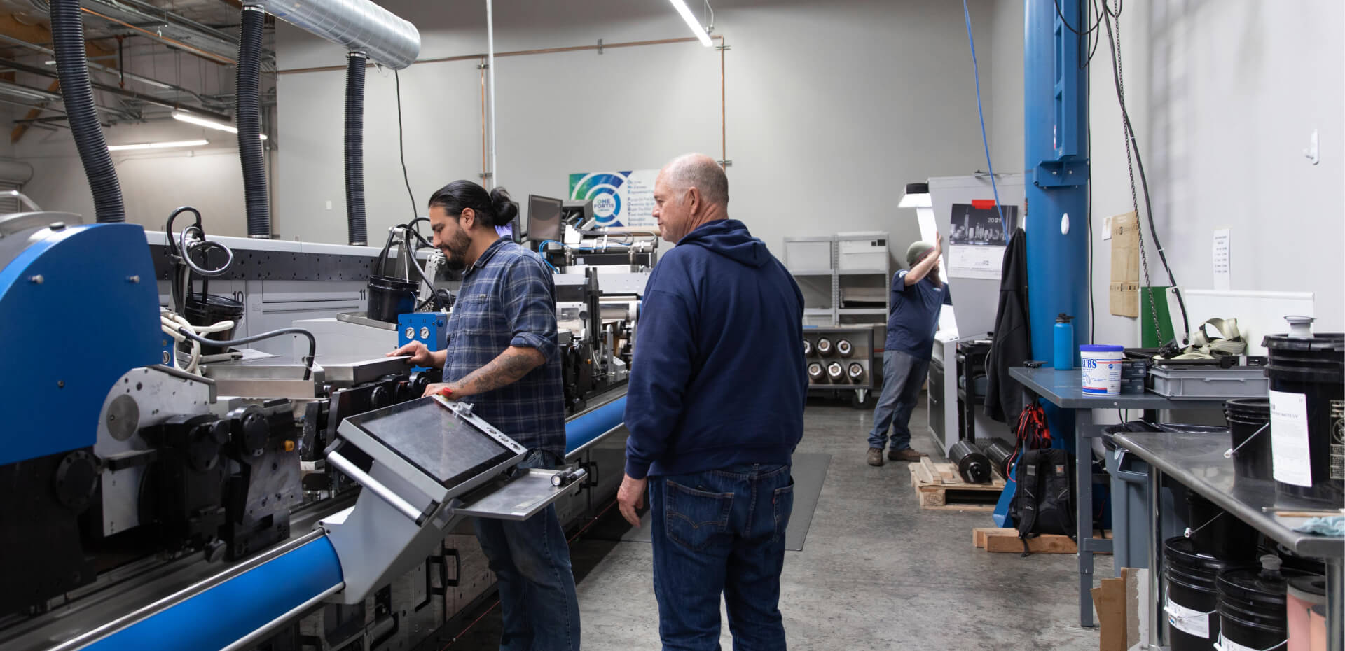 Two men packaging goods in a factory.
